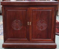 A 20th century Oriental hardwood bar/drinks cabinet with folding counter top over pair of cabinet