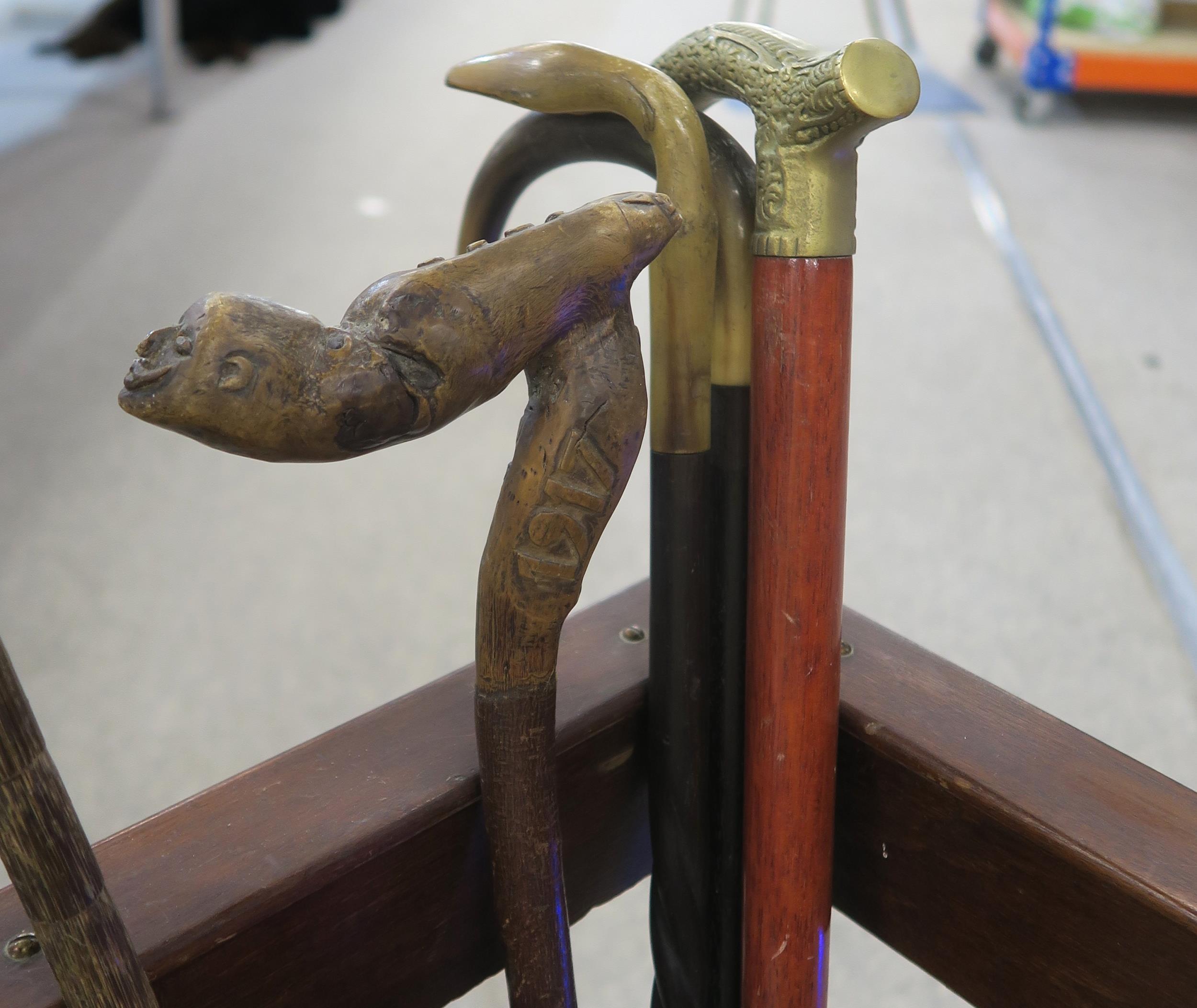 A collection of walking sticks, to include an example with root wood handle, carved with the face of - Image 2 of 2