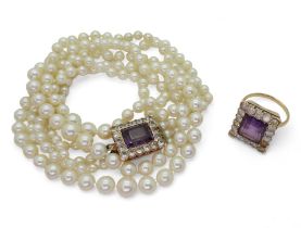 A triple string of cultured pearls with a yellow metal amethyst and clear gem set clasp, length of