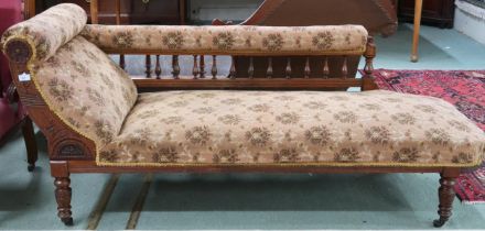 A Victorian oak framed chaise longue with spinel back and scroll end on turned supports