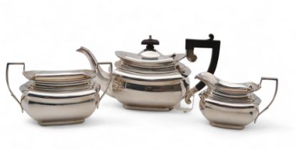 A three piece silver tea service, by I F & Son, London 1945, of faceted form, with an ebonised