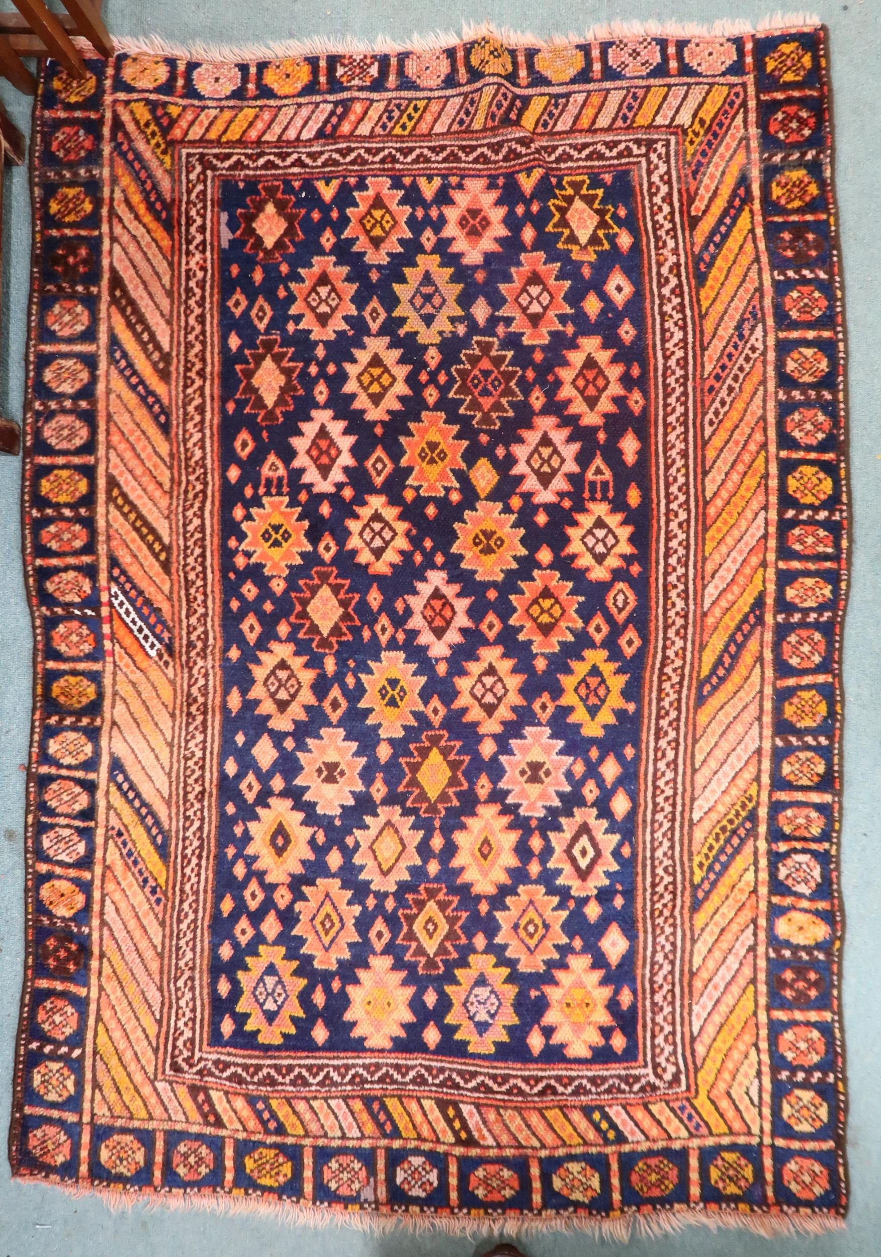 A dark blue ground Persian Qashqai rug with burnt orange geometric pattern within burnt orange