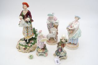 A collection of European figures including a Derby figure of a lady with a lamb at her feet etc