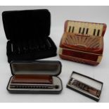 A piano accordion music box together with a Suzuki G-48 wooden cover harmonica and various blues