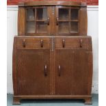 An early 20th century oak Art Deco sideboard with pair of bow fronted glazed doors over two short