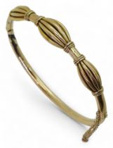 A yellow metal bangle, with oval pleated bead design (af) diameter 6.2cm, weight 12gms Condition
