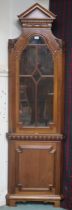 A 20th century reproduction corner display cabinet with architectural style dentil cornice over