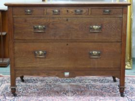 An early 20th century oak Arts & Craft chest of drawers with three short over two long drawers on