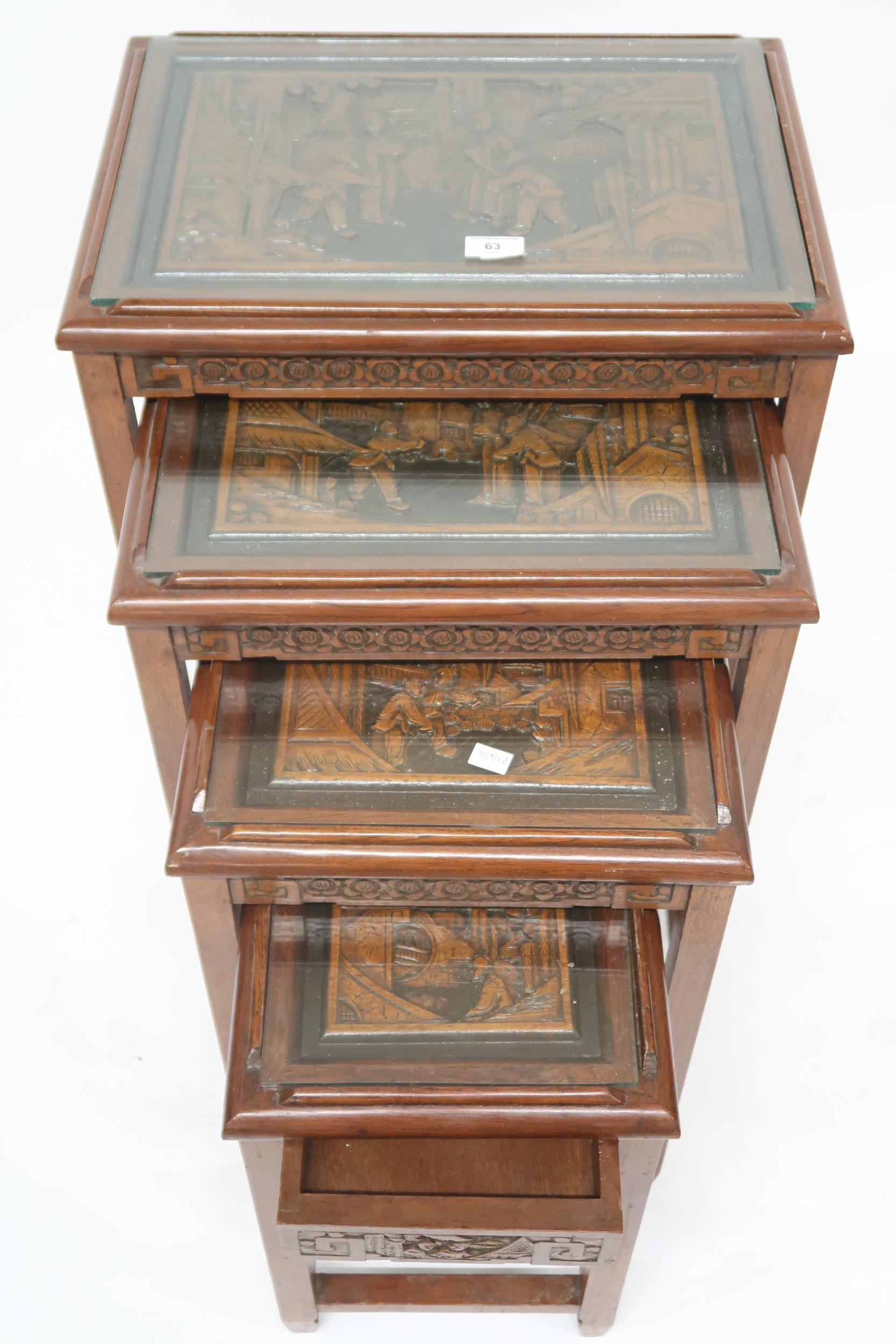 A Chinese nest of four tables, tops carved with village scenes under glass on square supports joined - Image 2 of 2