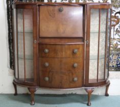 An early 20th century walnut veneered serpentine front bureau bookcase with central fall front