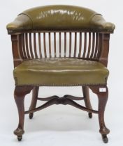 An early 20th century captains style desk chair with green studded leather upholstered back rest and