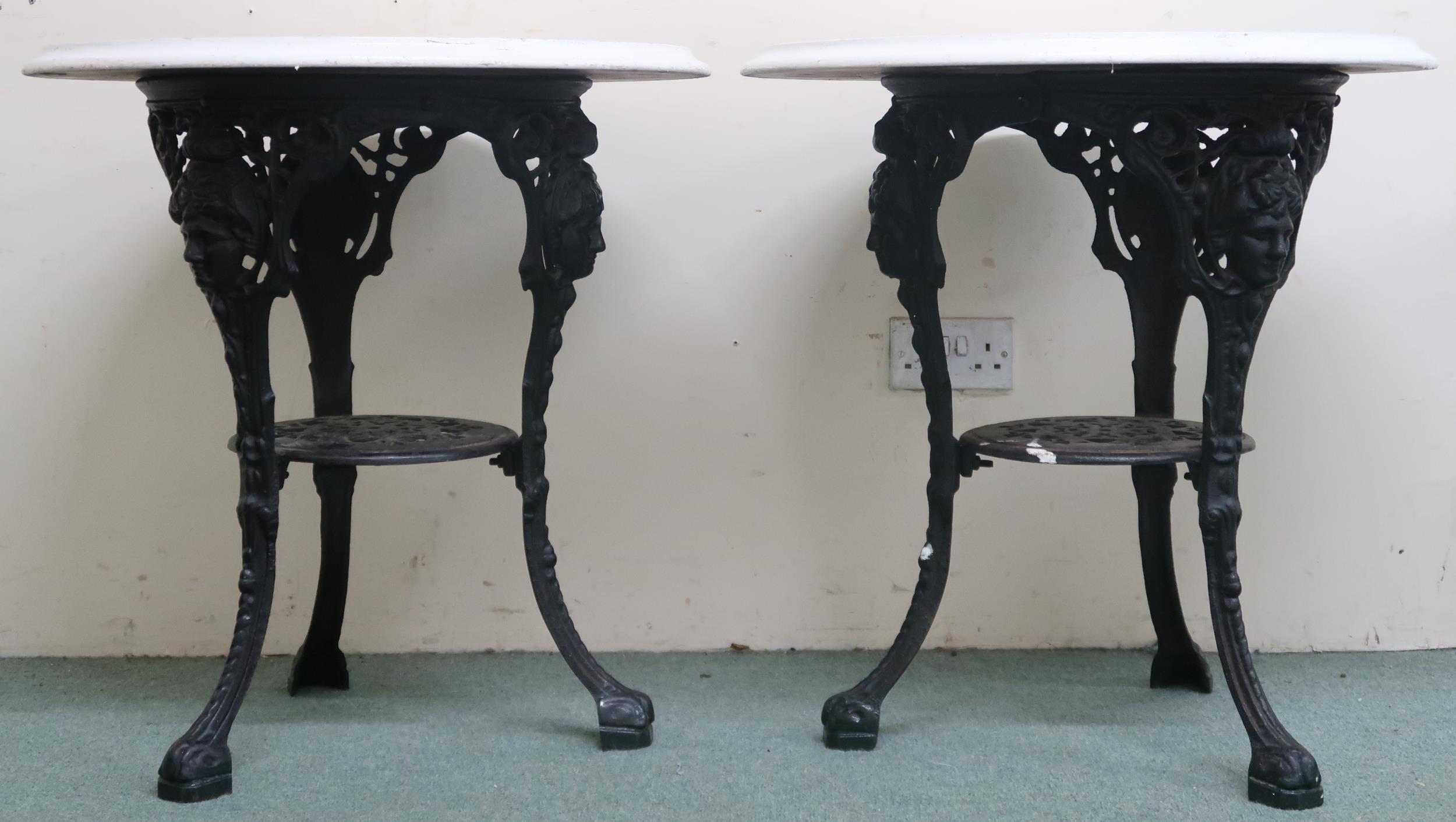 A pair of late 19th/ early 20th century pub/bar tables with painted circular tops on cast iron bases