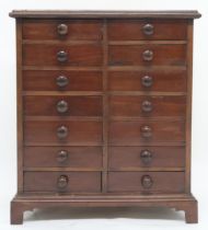 An early 20th century mahogany collectors chest with seven pairs of short drawers on plinth base,