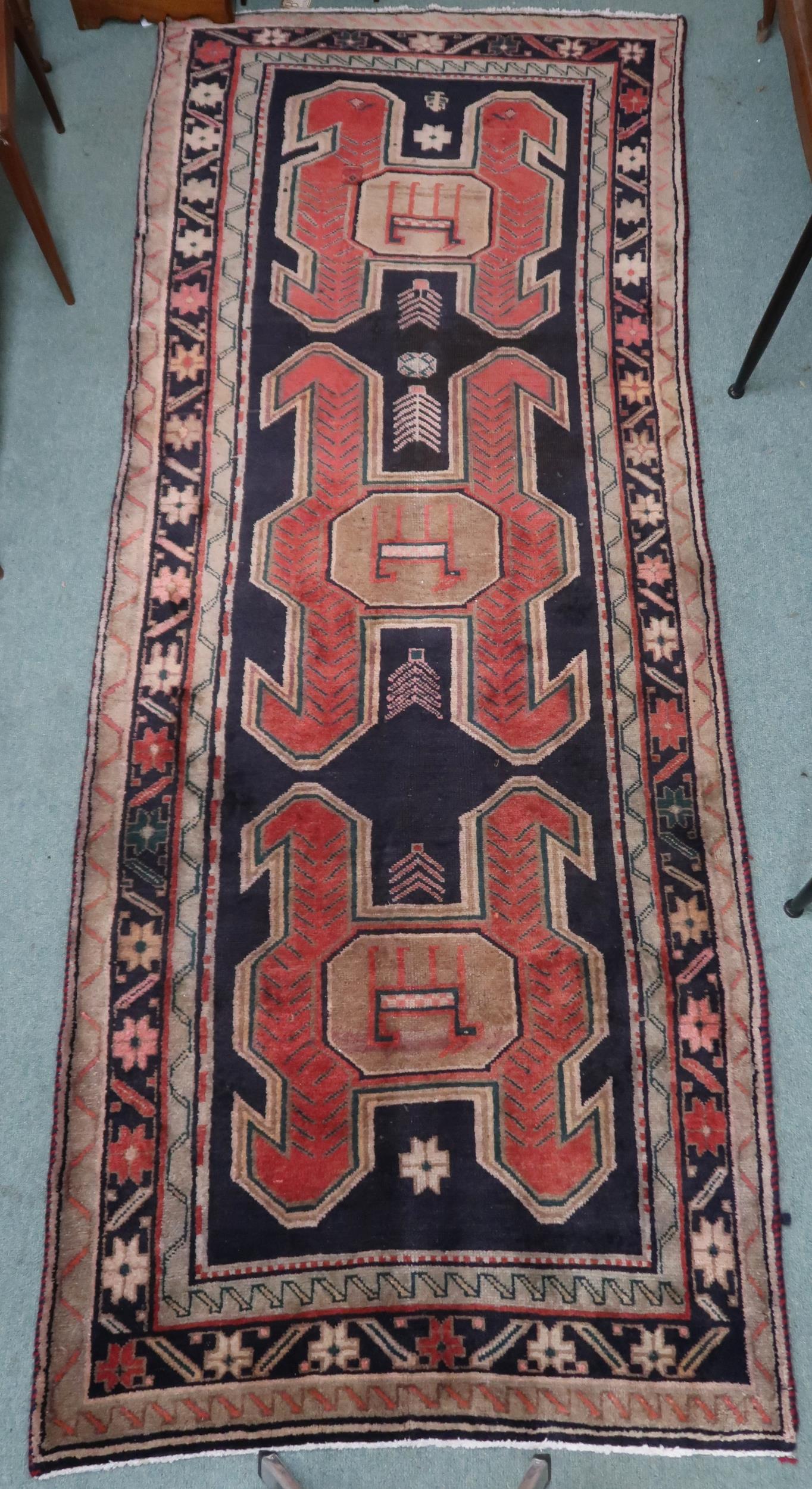 A dark ground Traditional Persian Meshkin runner with geometric medallion design decorated with