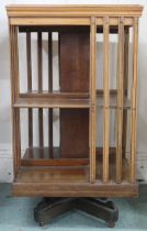 An early 20th century mahogany revolving bookcase with square top over two tiers of shelves with