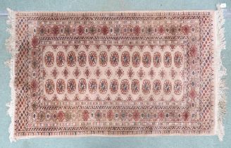 A beige ground Pakistani Bokhara rug with lozenge patterned ground within multicoloured geometric