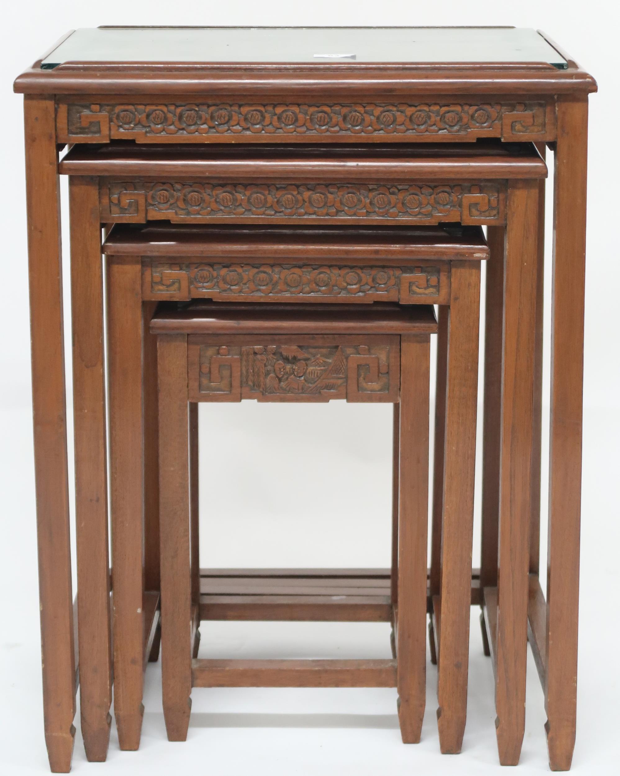 A Chinese nest of four tables, tops carved with village scenes under glass on square supports joined