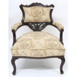 A Victorian ebonised parlour armchair with floral upholstery applied to back, arms and seat on