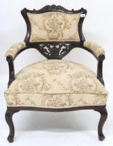 A Victorian ebonised parlour armchair with floral upholstery applied to back, arms and seat on