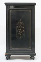 A 19th century continental ebonised music cabinet with single gilt decorated panel door concealing