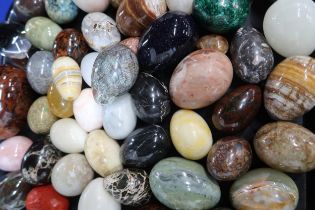 A collection of hardstone eggs including blue glitter stone, malachite, agates, marbles, fossils etc