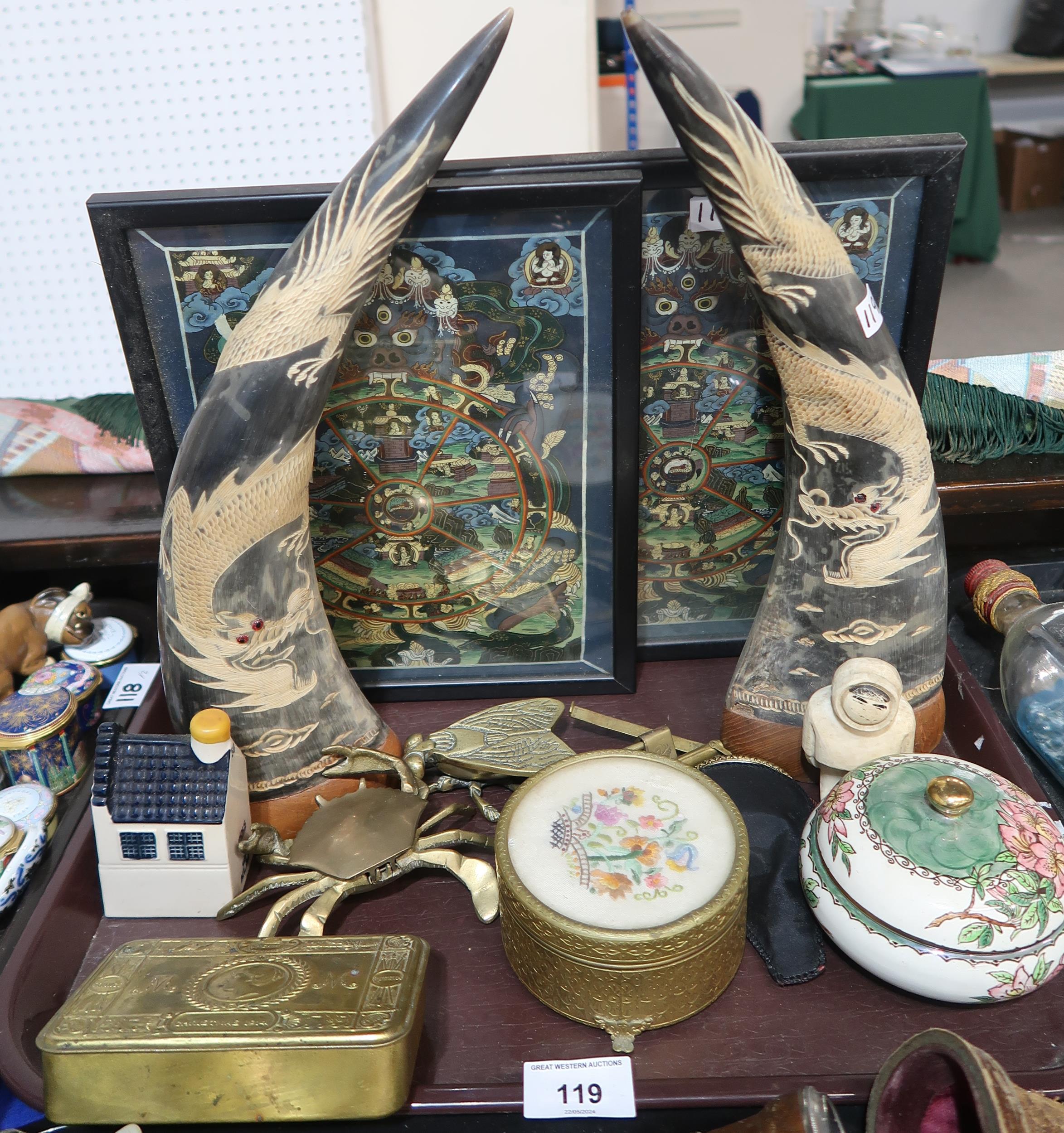 A pair of carved horns, a pair of framed hand painted thangkas, a Christmas tin, and other items