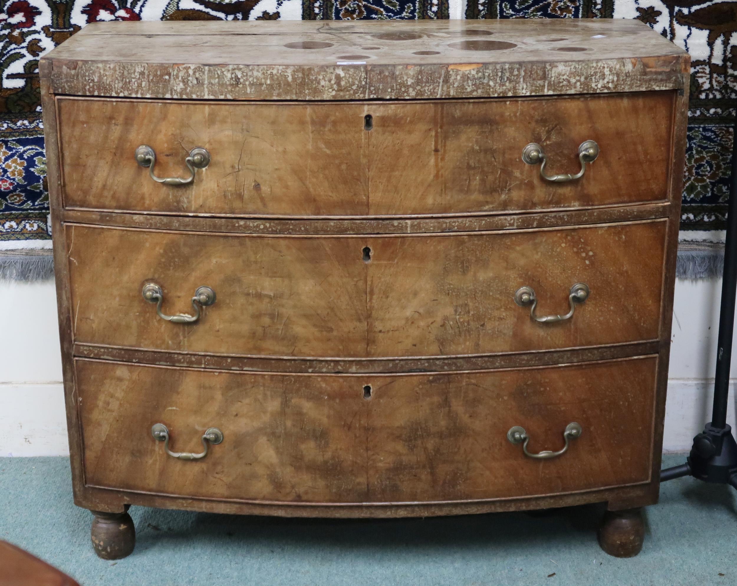 A Georgian walnut veneered bow front chest of three drawers on turned feet, 78cm high x 90cm wide