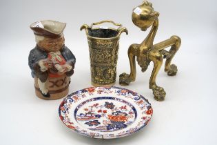A Doulton stoneware toby jug, a Amherst Ironstone plate, a brass fire dog and brass pail Condition