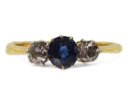 An 18ct gold sapphire and diamond three stone, set with two 0.10ct old cut diamonds flanking an oval