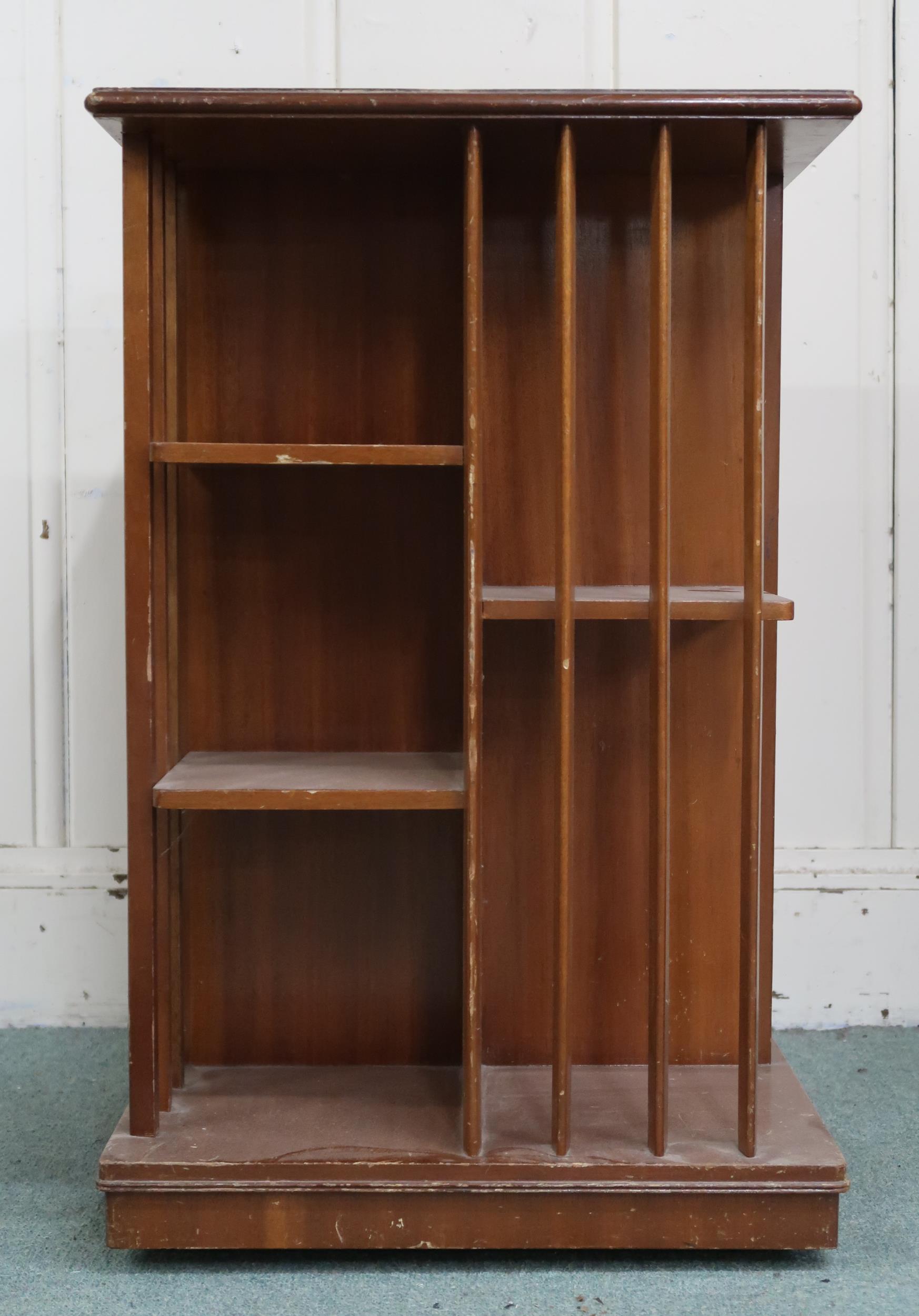 An early 20th century mahogany revolving bookcase with square top over asymmetrical shelves with