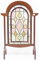 A late 19th/early 20th century mahogany framed leaded stained glass fire screen on bowed supports (