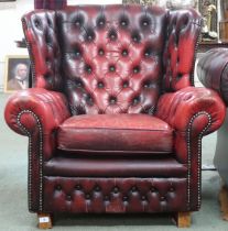 A 20th century oxblood buttonback leather upholstered Chesterfield style wingback armchair, 97cm