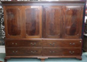 A large 20th century mahogany veneered linen press/wardrobe with dentil cornice over two pairs of