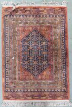 A terracotta ground fine full pile Bijar rug with dark blue geometric central medallion within