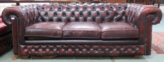 A 20th century oxblood buttonback leather upholstered Chesterfield style club settee, 74cm high x