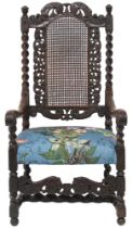 A 17TH CENTURY STYLE OAK BARLEY TWIST ARMCHAIR  with cane back framed by carved pierced decoration