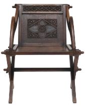 A 19TH CENTURY OAK GLASTONBURY CHAIR  backrest and arms carved with Gothic floral/foliate motifs