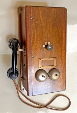 A large, wood cased Signal Box Telephone with bakelite handset in side cradle. Has a 4 position