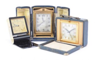 A Jaeger-LeCoultre travel alarm clock and two other travel clocks