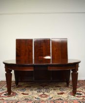 A reproduction mahogany wind-out extending dining table