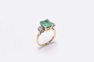 A three stone emerald and diamond ring