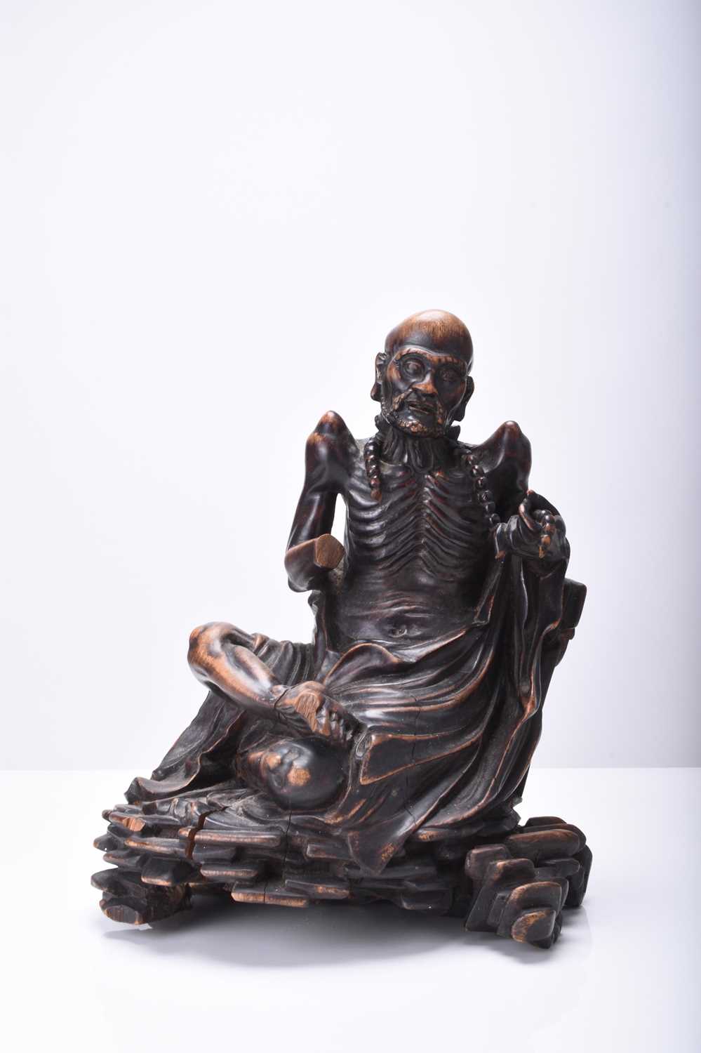 A Chinese carved wood figure of a seated Luohan, Qing Dynasty