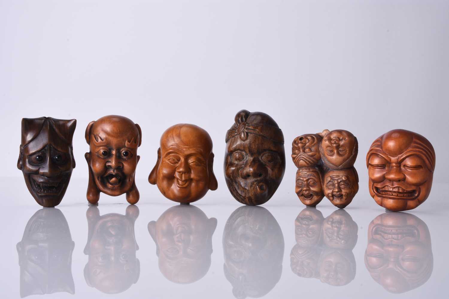 A group of six Japanese wood netsuke of masks, 20th century
