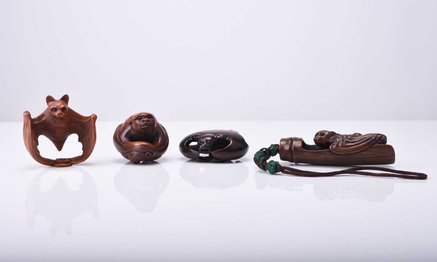 A group of four Japanese wood netsuke modelled as bats, 20th century