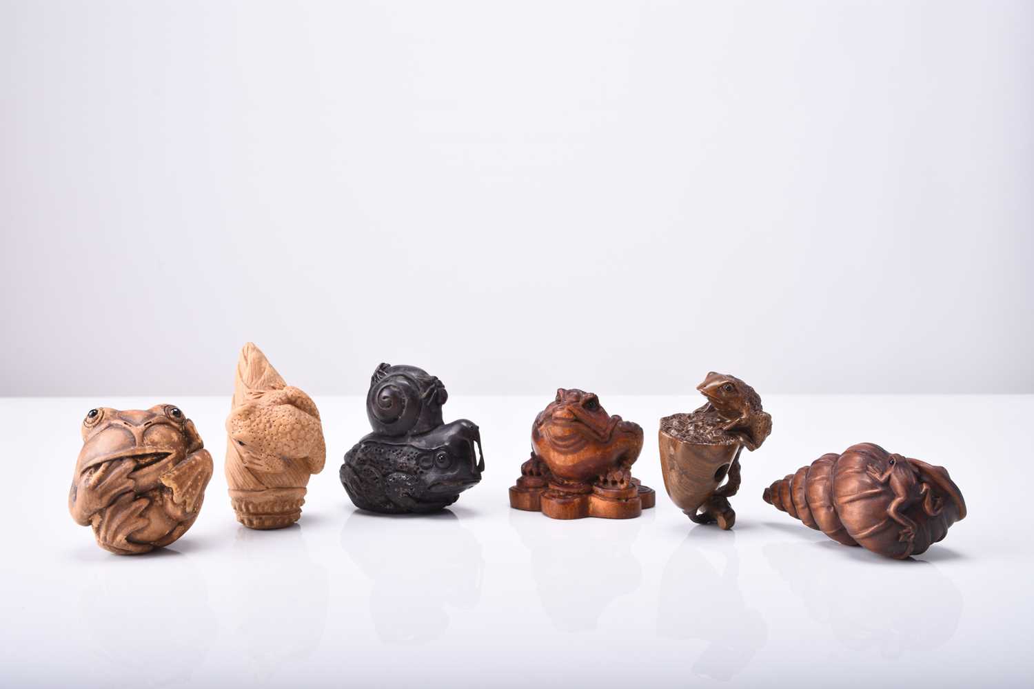 A group of six Japanese wood netsuke of frogs and toads, 20th century