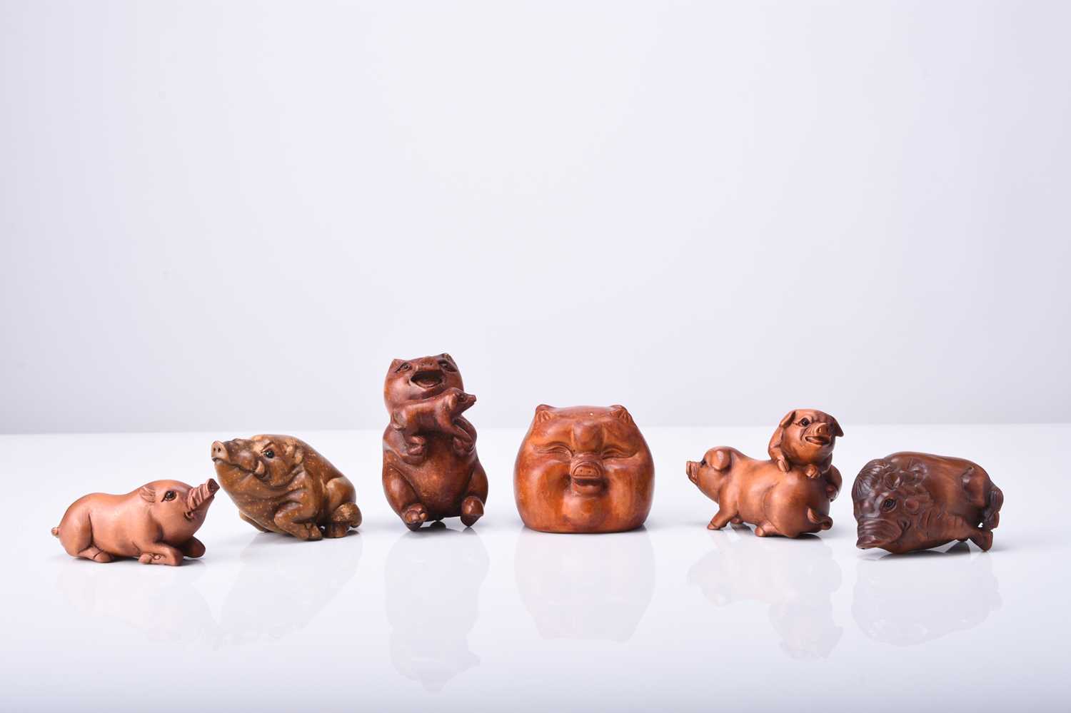 A group of six Japanese wood netsuke of pigs and boars, 20th century