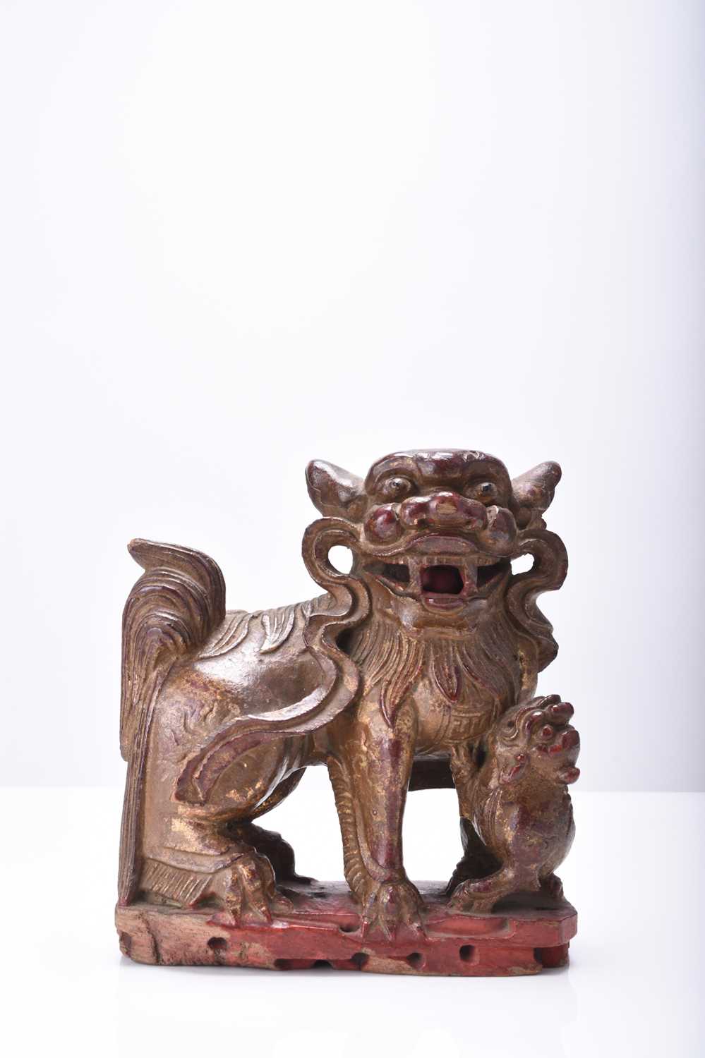 A Chinese carved and painted wood figure of a guardian lion, Qing Dynasty