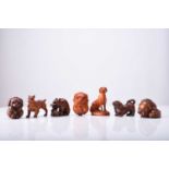 A group of seven Japanese wood netsuke of dogs and puppies, 20th century