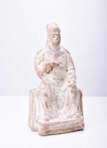 A Chinese buff pottery figure of a seated official, Tang Dynasty