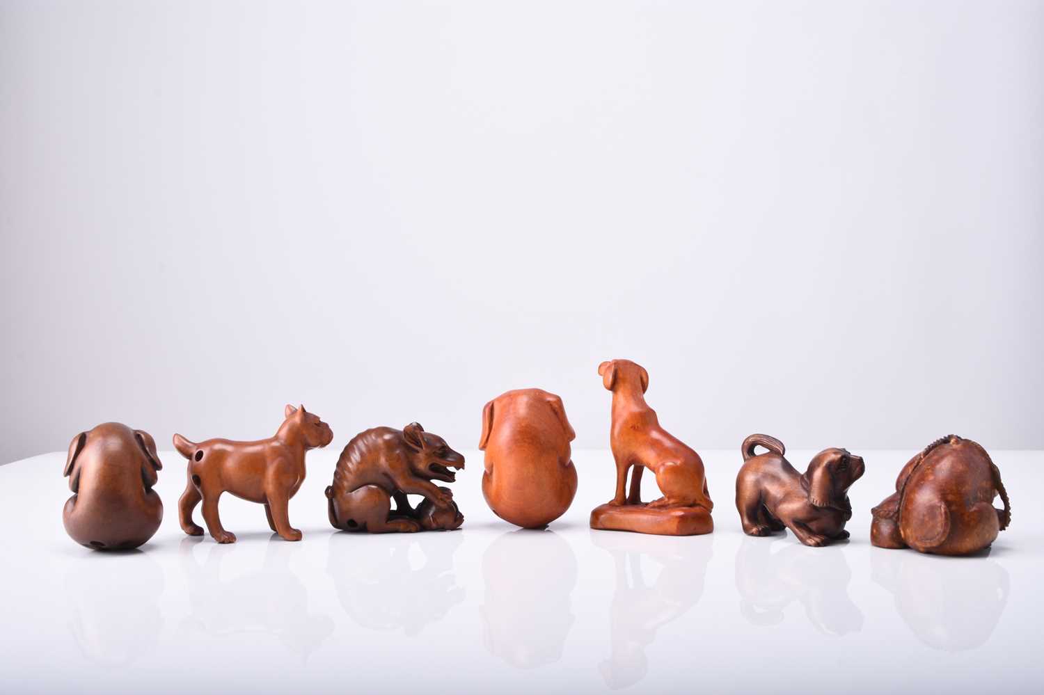 A group of seven Japanese wood netsuke of dogs and puppies, 20th century - Image 2 of 2